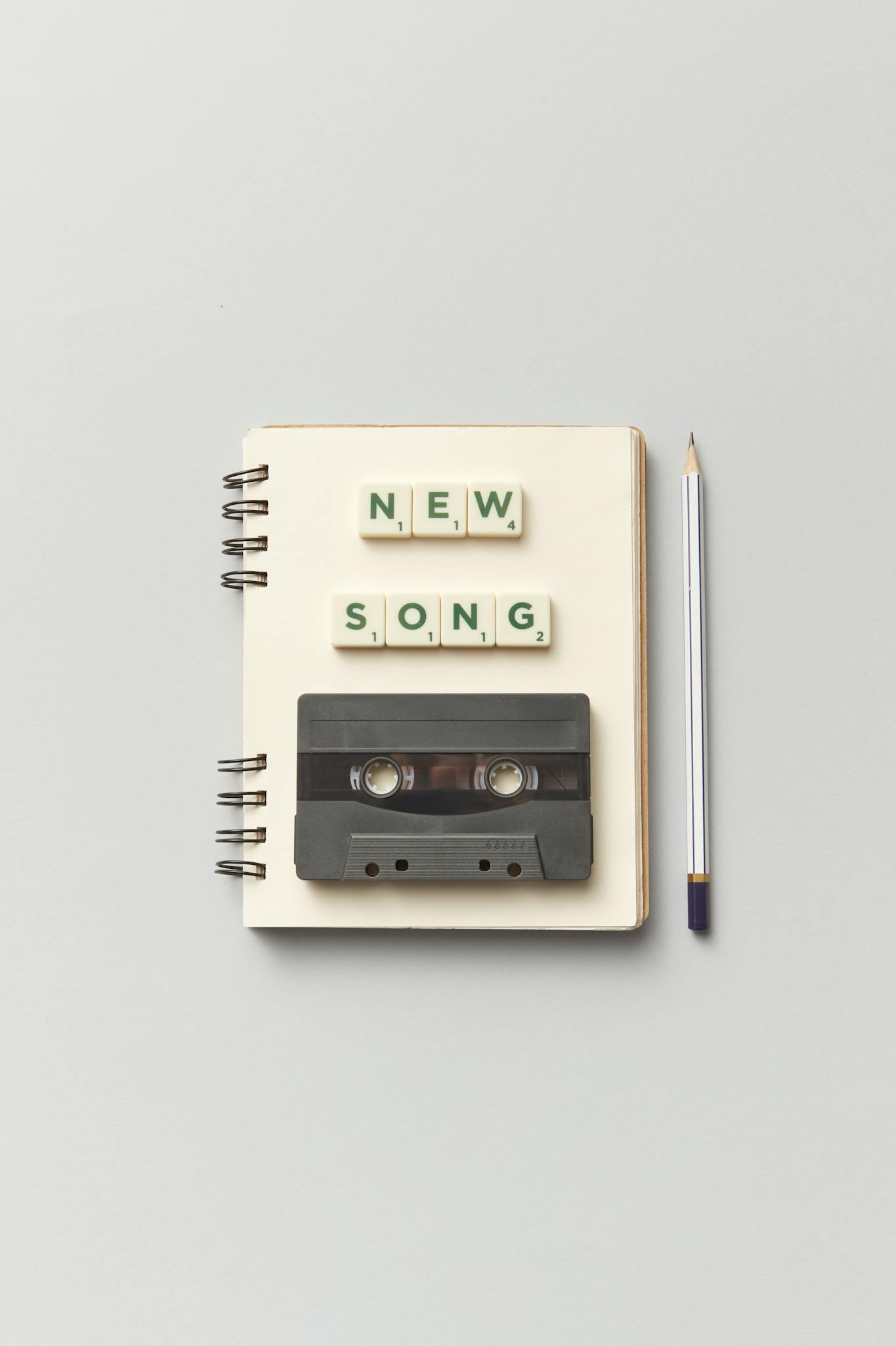 Close-up of a notebook with a vintage cassette and 'New Song' text, perfect for music lovers.
